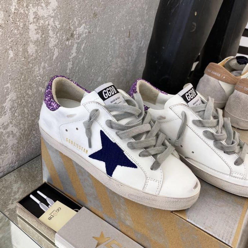 white S*per-star sneakers with blue star and glittery heel tab