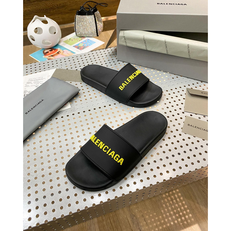 Ba*len*cia*ga pool slide sandal in black rubber with yellow 3d Ba*len*cia*ga logo