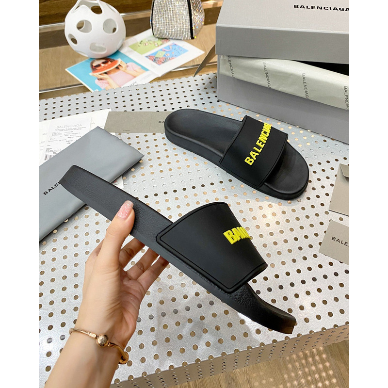 Ba*len*cia*ga pool slide sandal in black rubber with yellow 3d Ba*len*cia*ga logo