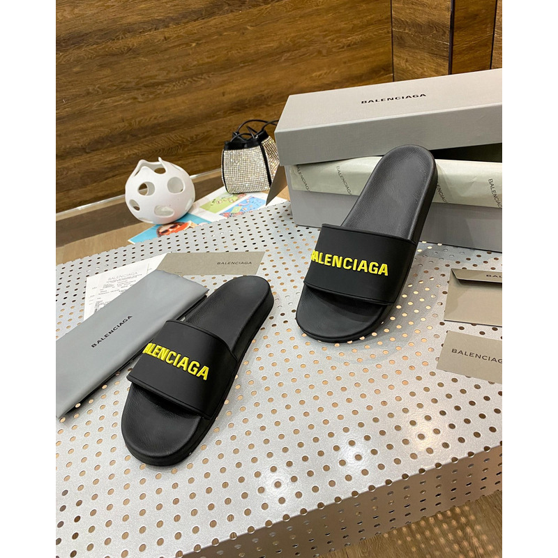 Ba*len*cia*ga pool slide sandal in black rubber with yellow 3d Ba*len*cia*ga logo