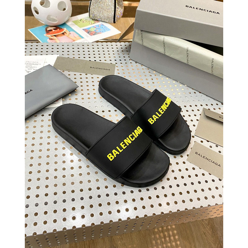 Ba*len*cia*ga pool slide sandal in black rubber with yellow 3d Ba*len*cia*ga logo